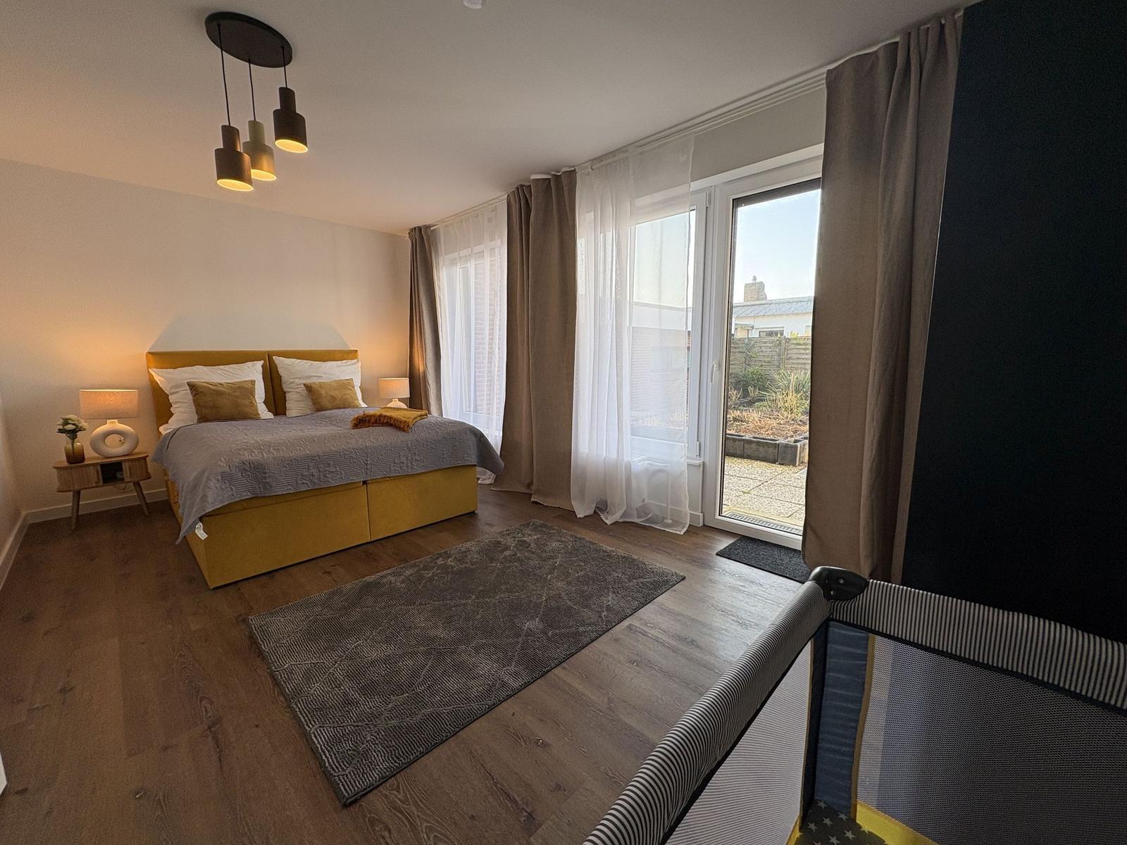 Schlafzimmer mit Bett, Fenster und Bodenbelag