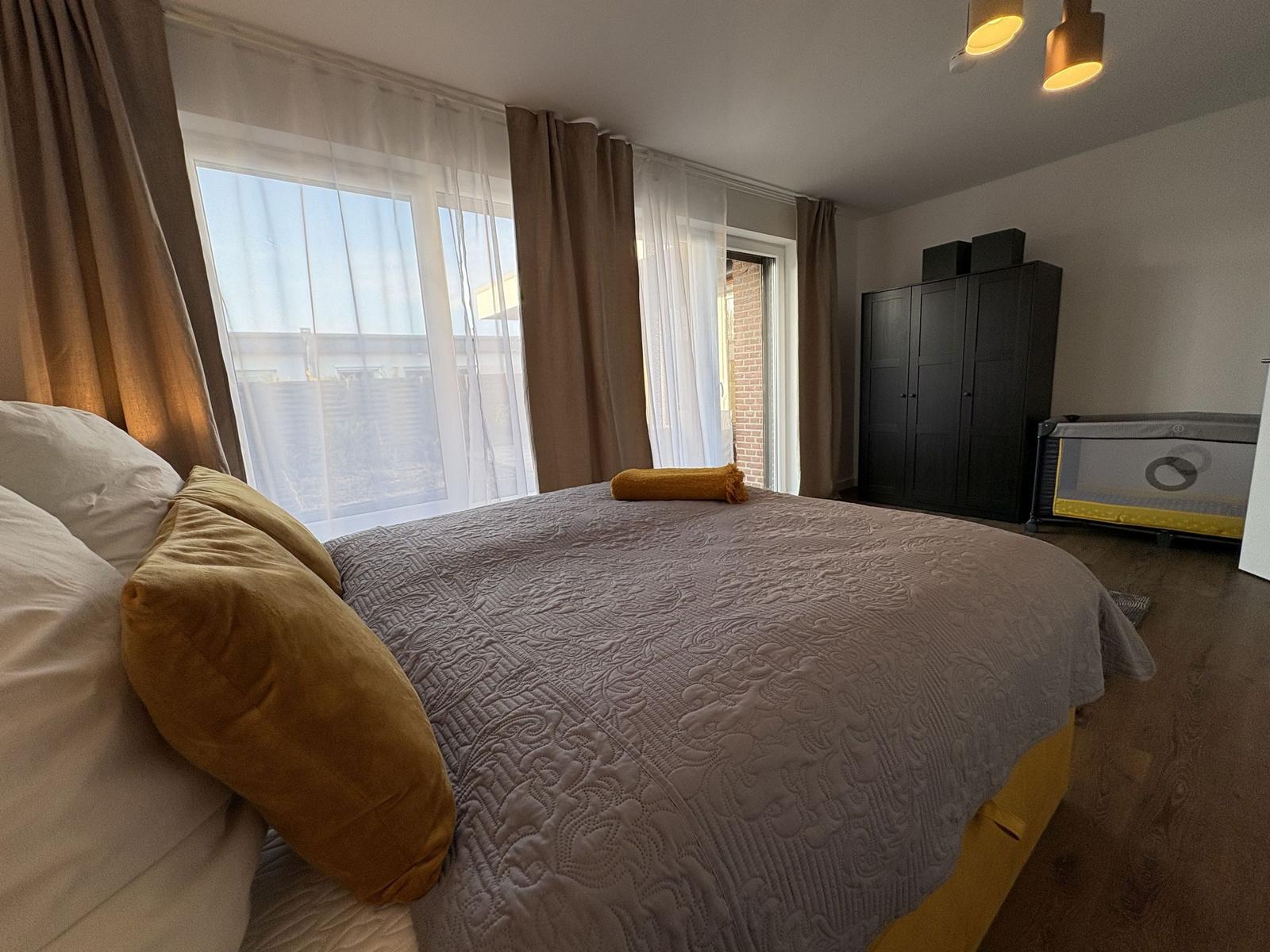 Schlafzimmer mit Bett, Fenster und Kleiderschrank.