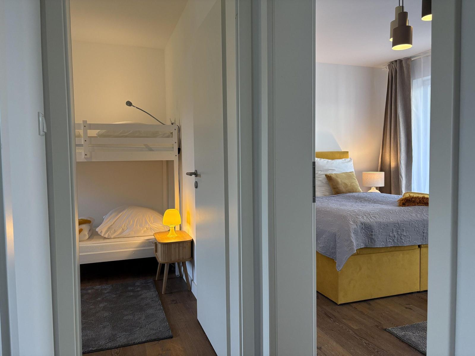 Zwei Schlafzimmer mit Bett, Nachttisch und Lampen.