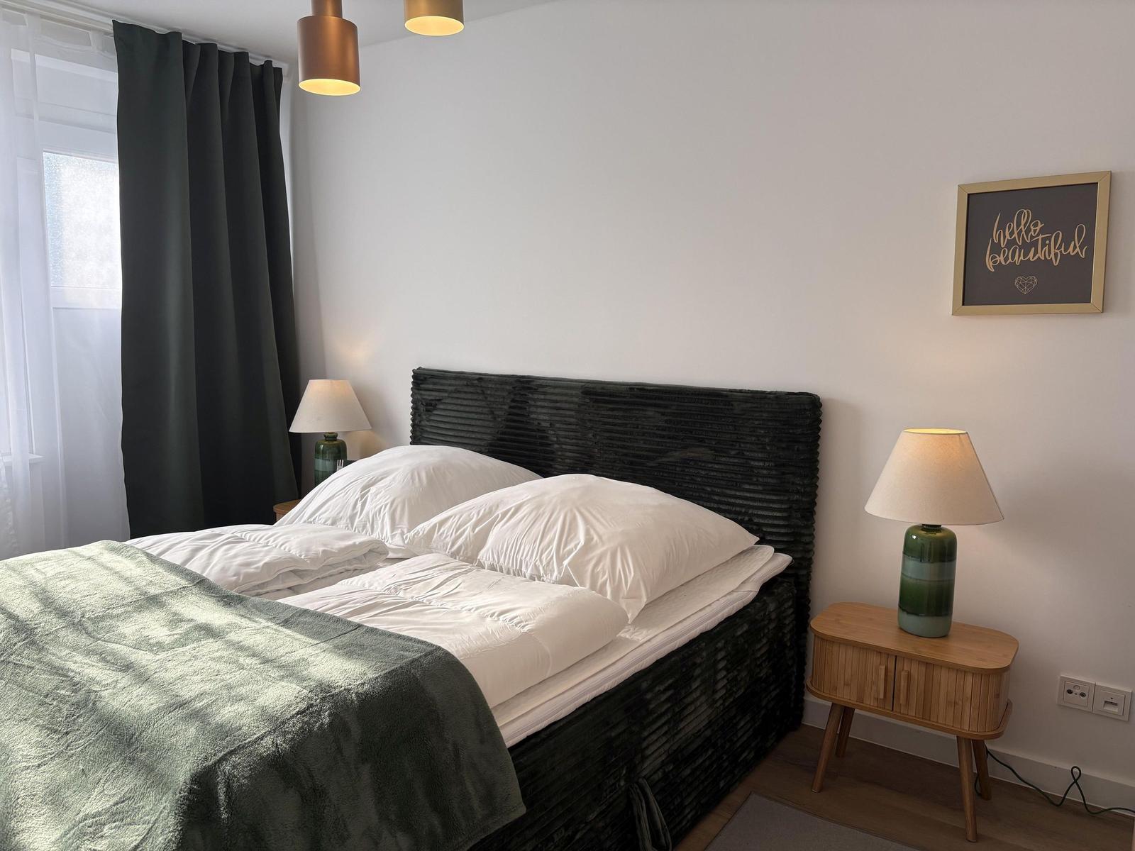 Schlafzimmer mit Doppelbett, Nachttisch und Lampe