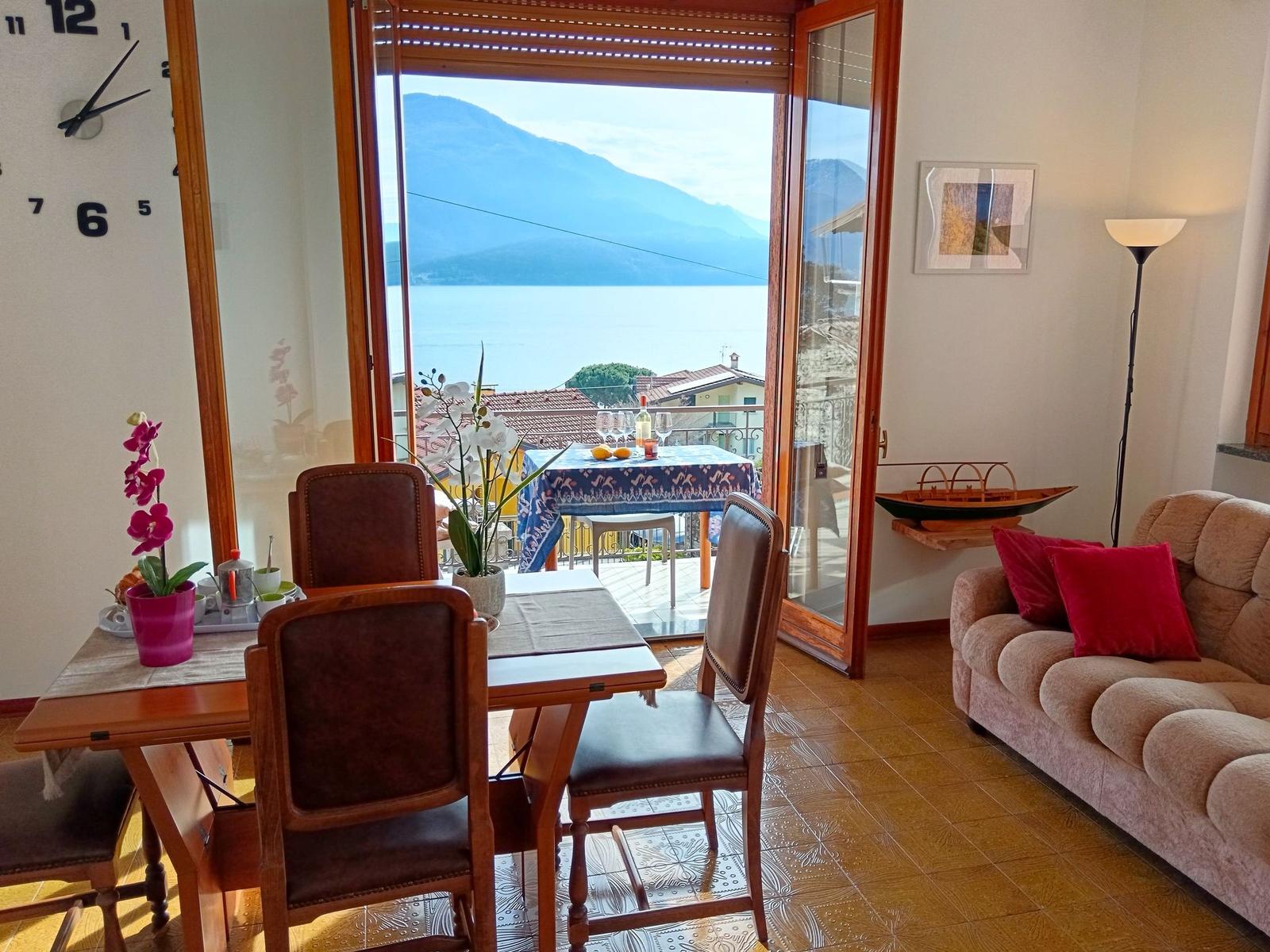 Esszimmer mit Blick auf See und Berge. Wohnbereich mit Sofa und Stehlampe.