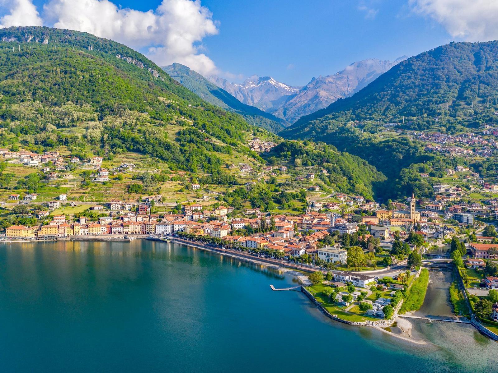 Ortschaft am See mit Bergen im Hintergrund