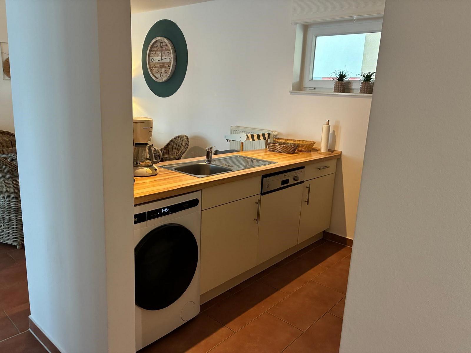 Küche mit Spüle, Waschmaschine und Waschbecken