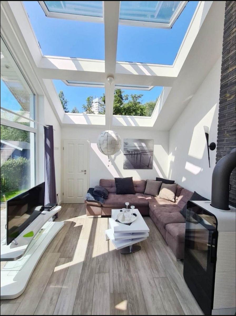 Wohnzimmer mit Dachfenstern, Sofa, Couchtisch und Fernseher.