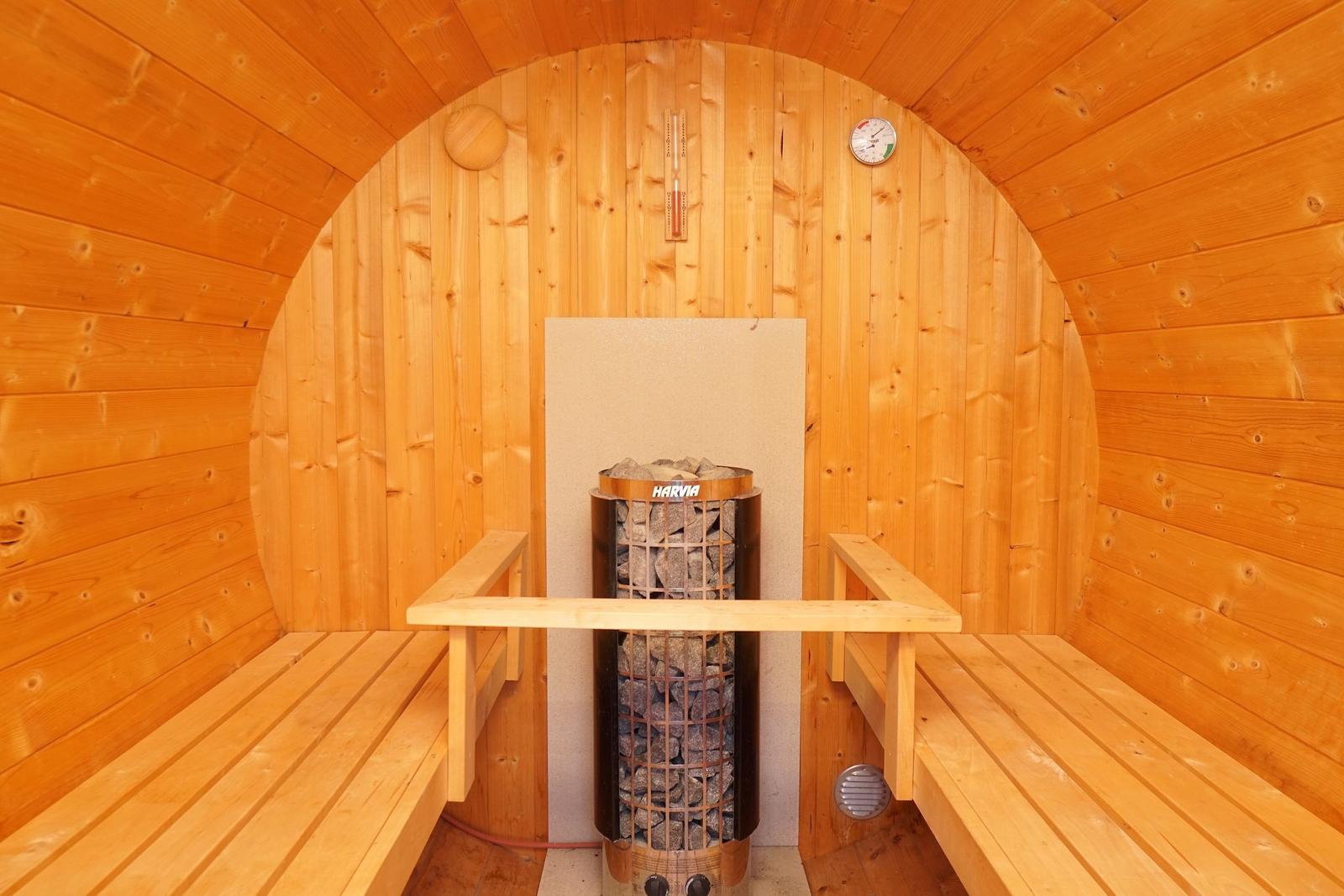 Sauna mit Holzbank und Steinkamin