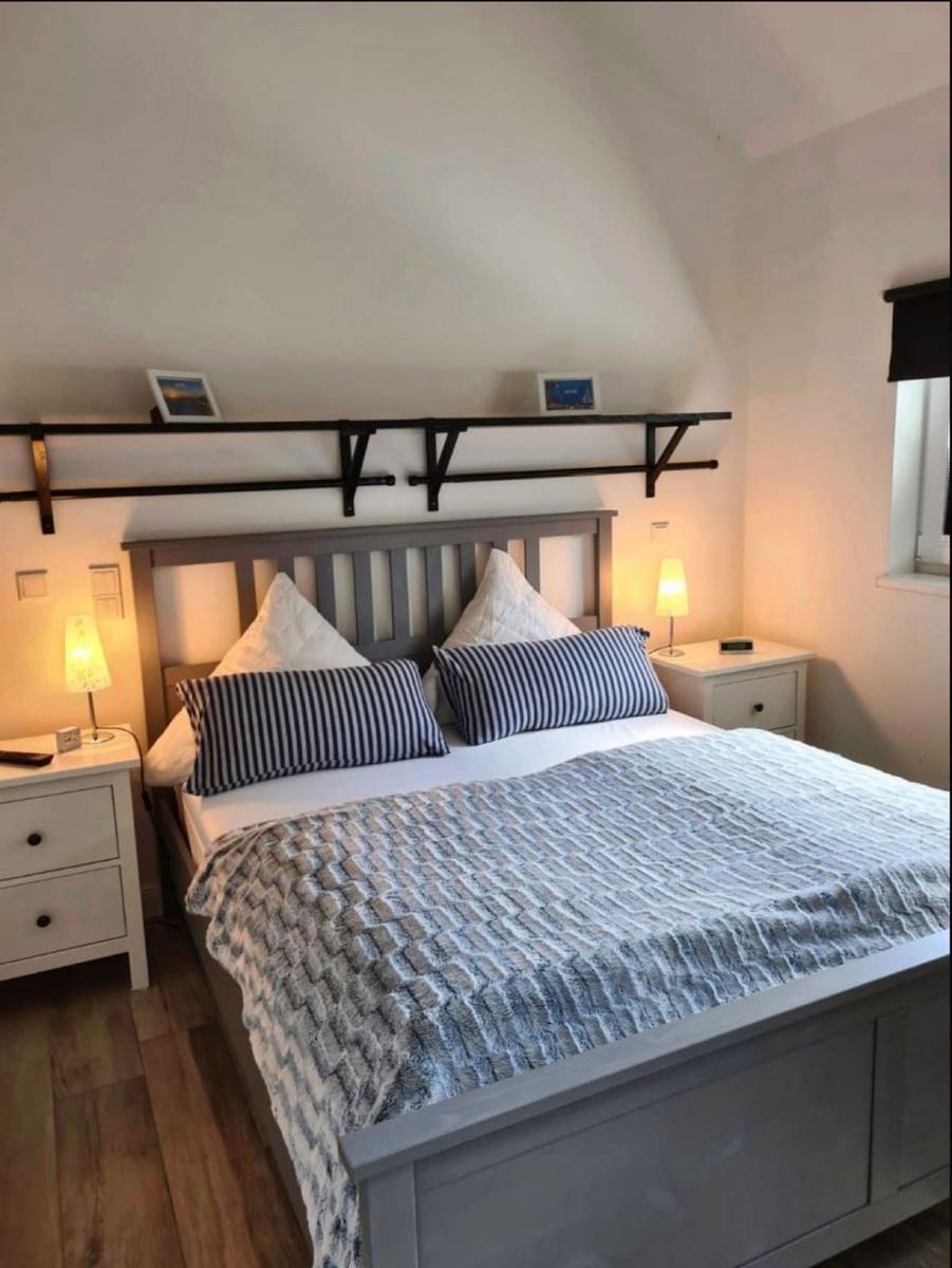 Schlafzimmer mit Doppelbett, Nachttischen und Stehlampe unter schrägem Dach