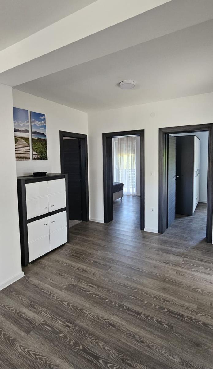 Wohnbereich mit dunklen Türen und Holzboden. An der Wand hängen zwei Bilder.