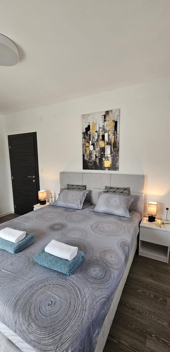 Schlafzimmer mit Doppelbett, zwei Nachttischen und Wandbild.