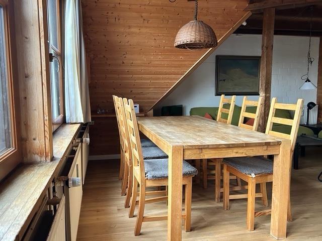 Essbereich mit Holztisch, Stühlen und Fensterblick