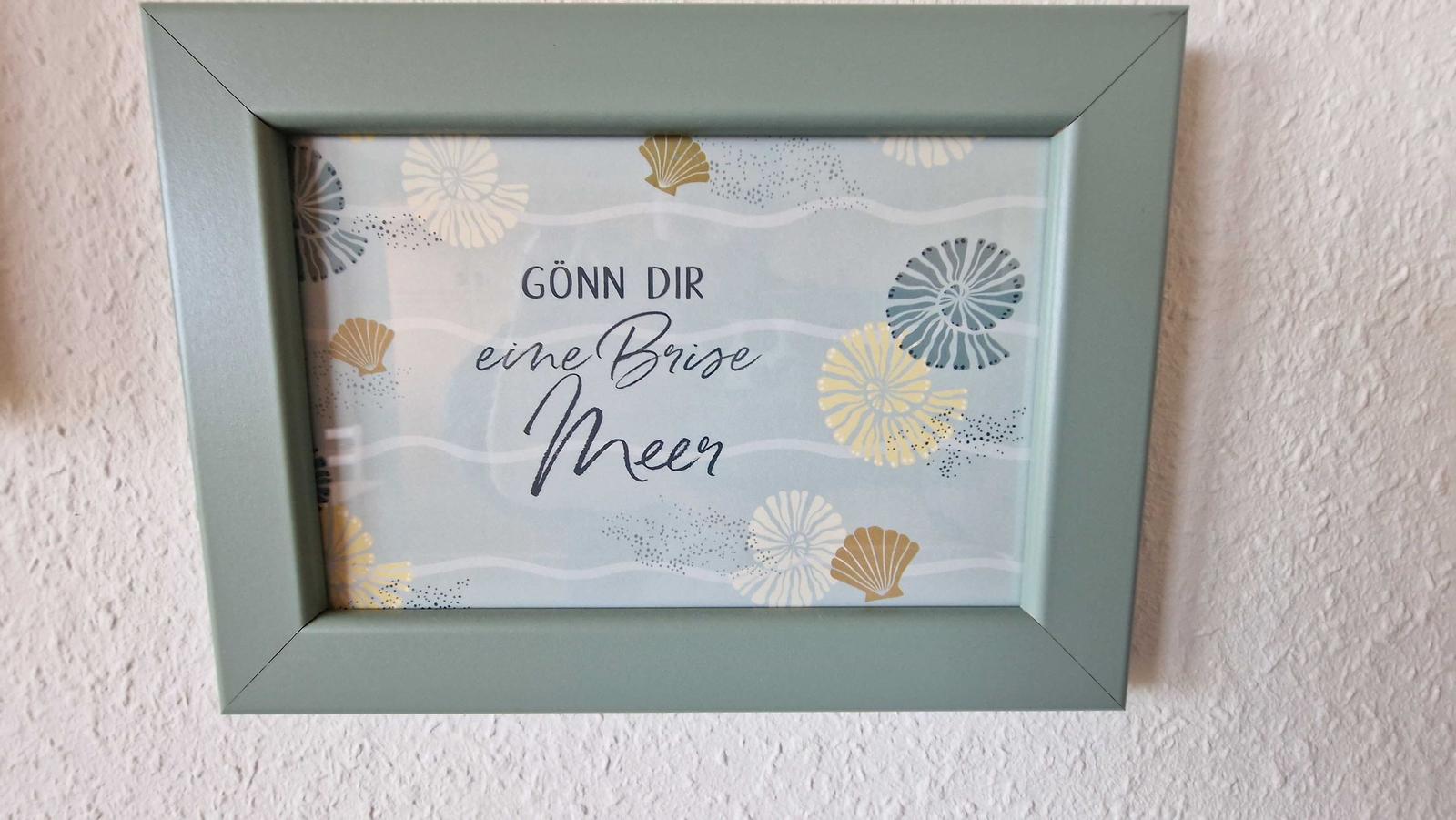 Gefasstes Bild mit Meeresmotiven und Text: Gönne dir eine Brise Meer.