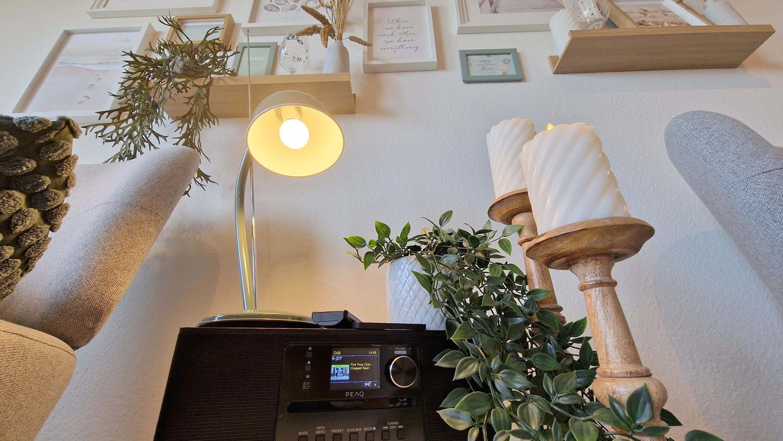 Lampe, Radio und Pflanzen auf einem Tisch zwischen zwei Sesseln