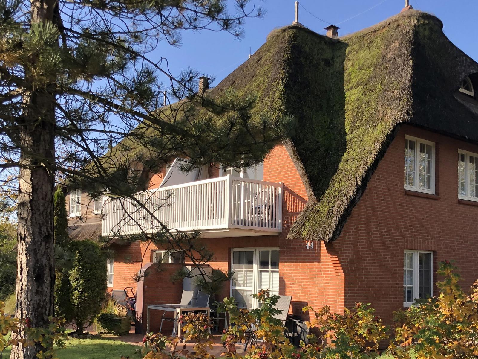 Haus mit Strohdach, Balkon und Garten. Nummer 44.