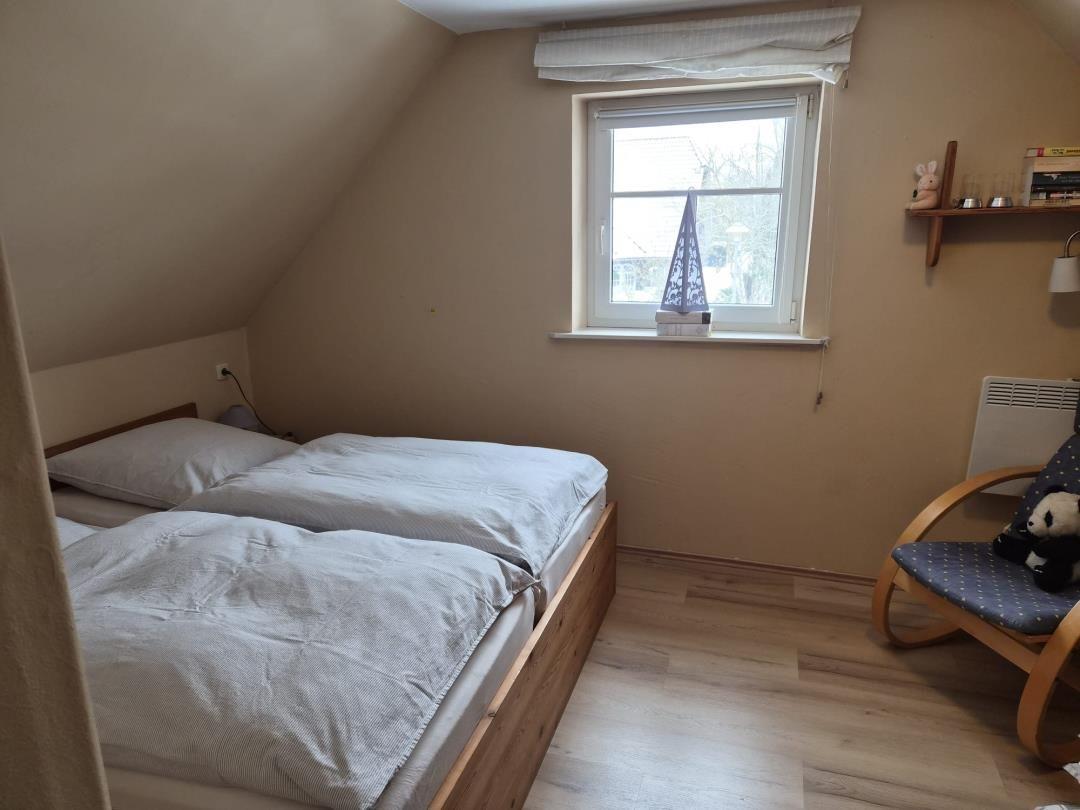 Bedroom with double bed, window and chair