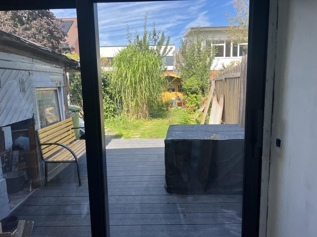 Deck with wooden bench and view of green garden