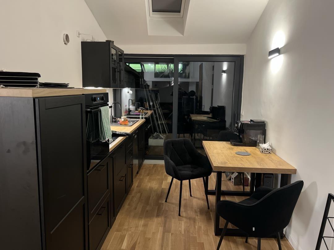 Kitchen with dining area and bedroom in the background.