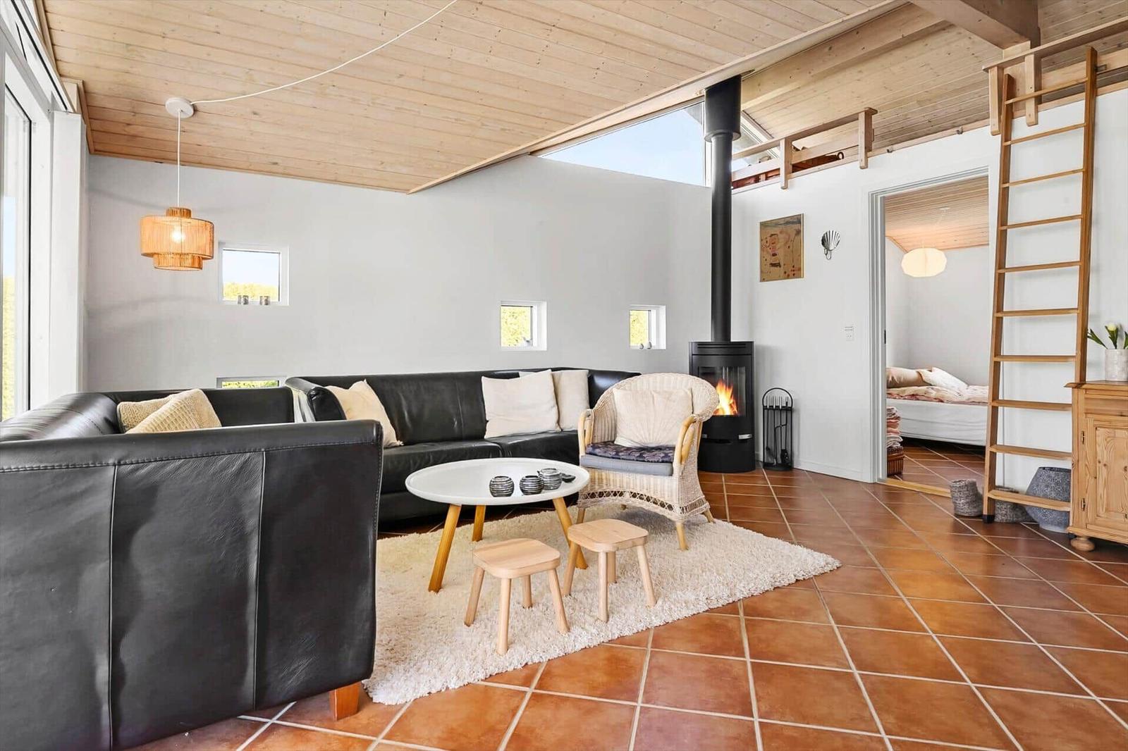 Living room with sofa, fireplace, and terracotta floor