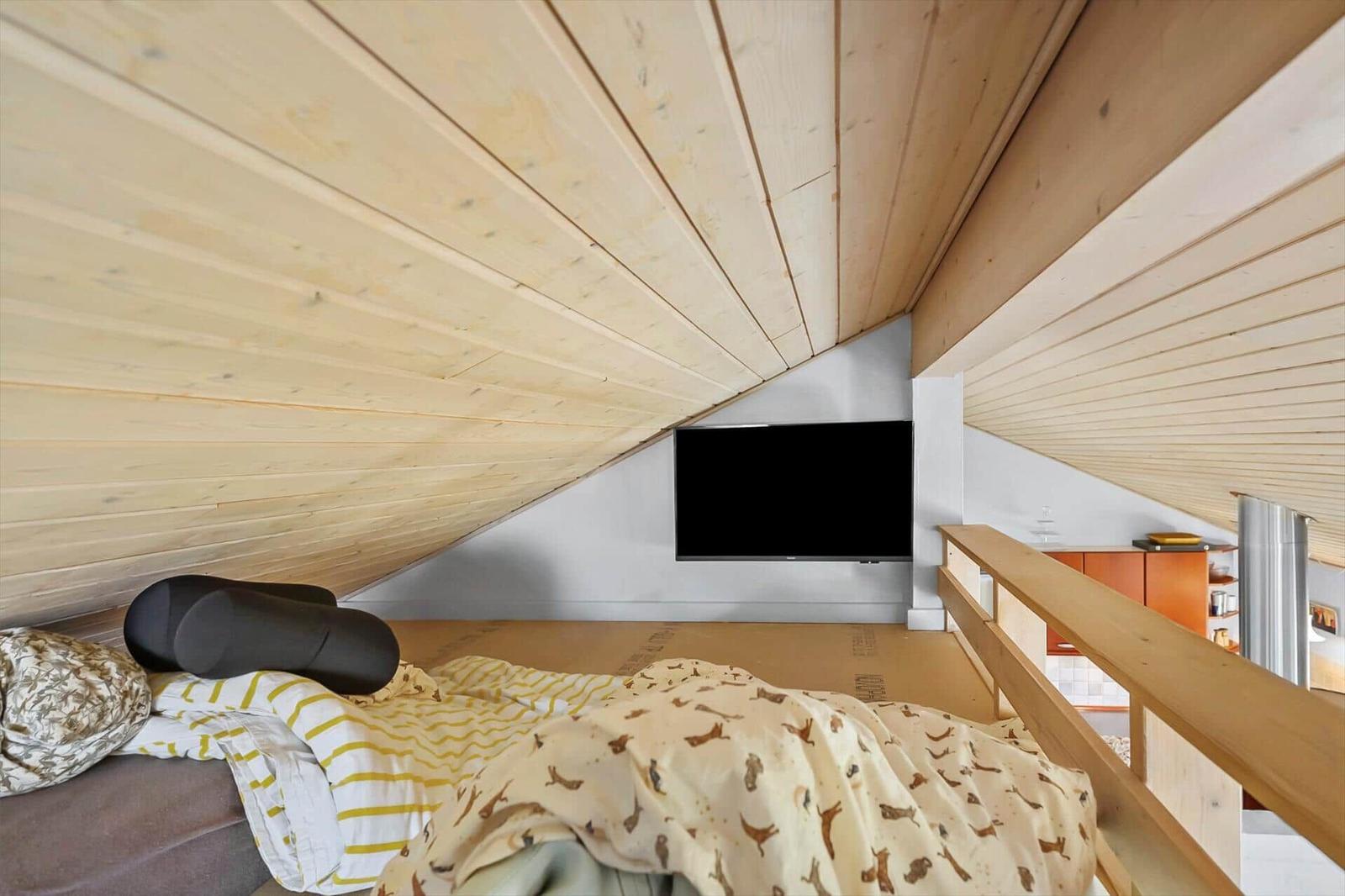 Bedroom with wooden ceiling, bed, and TV