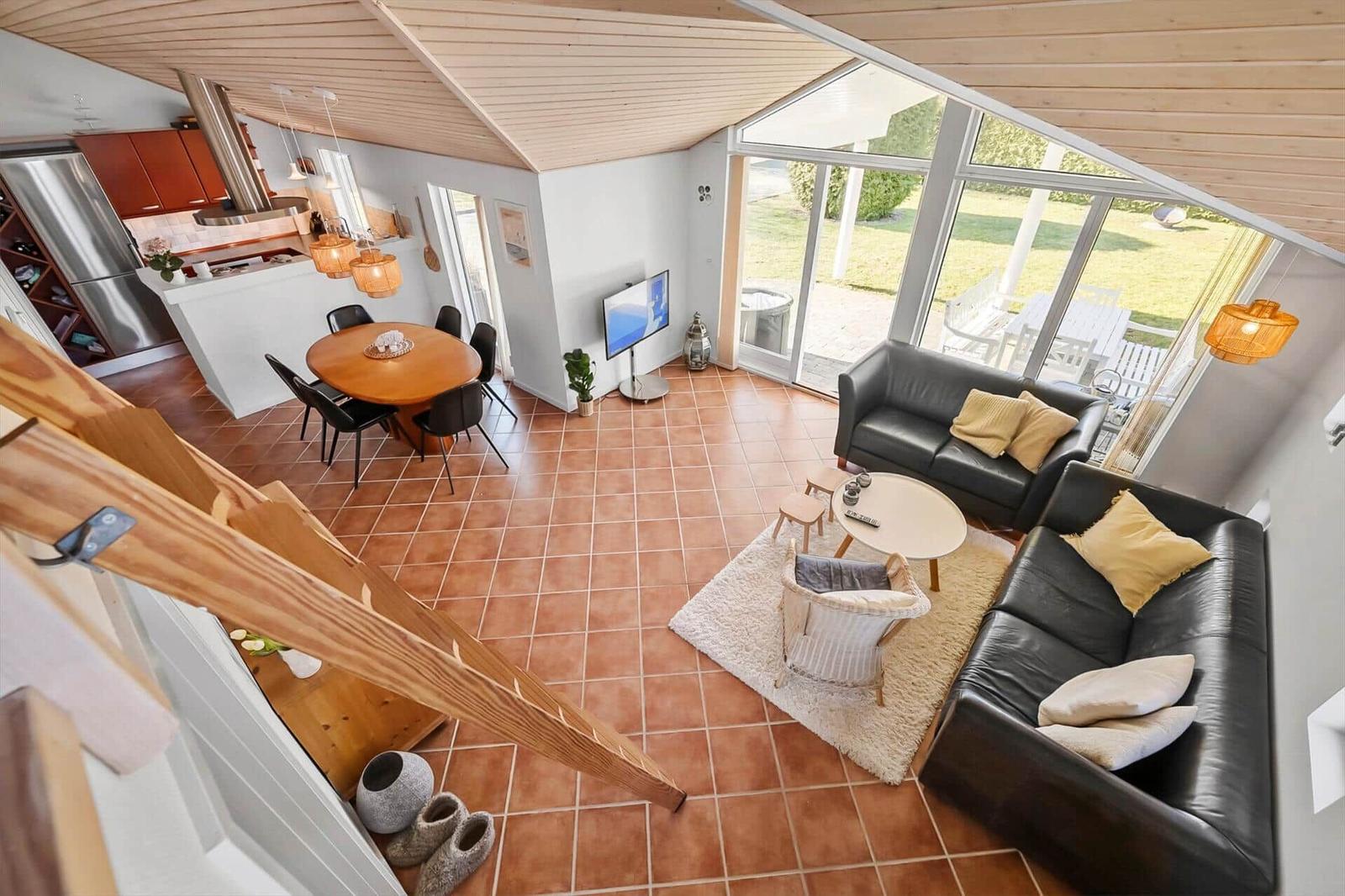 Living and dining area with kitchen, sofa, and terrace.
