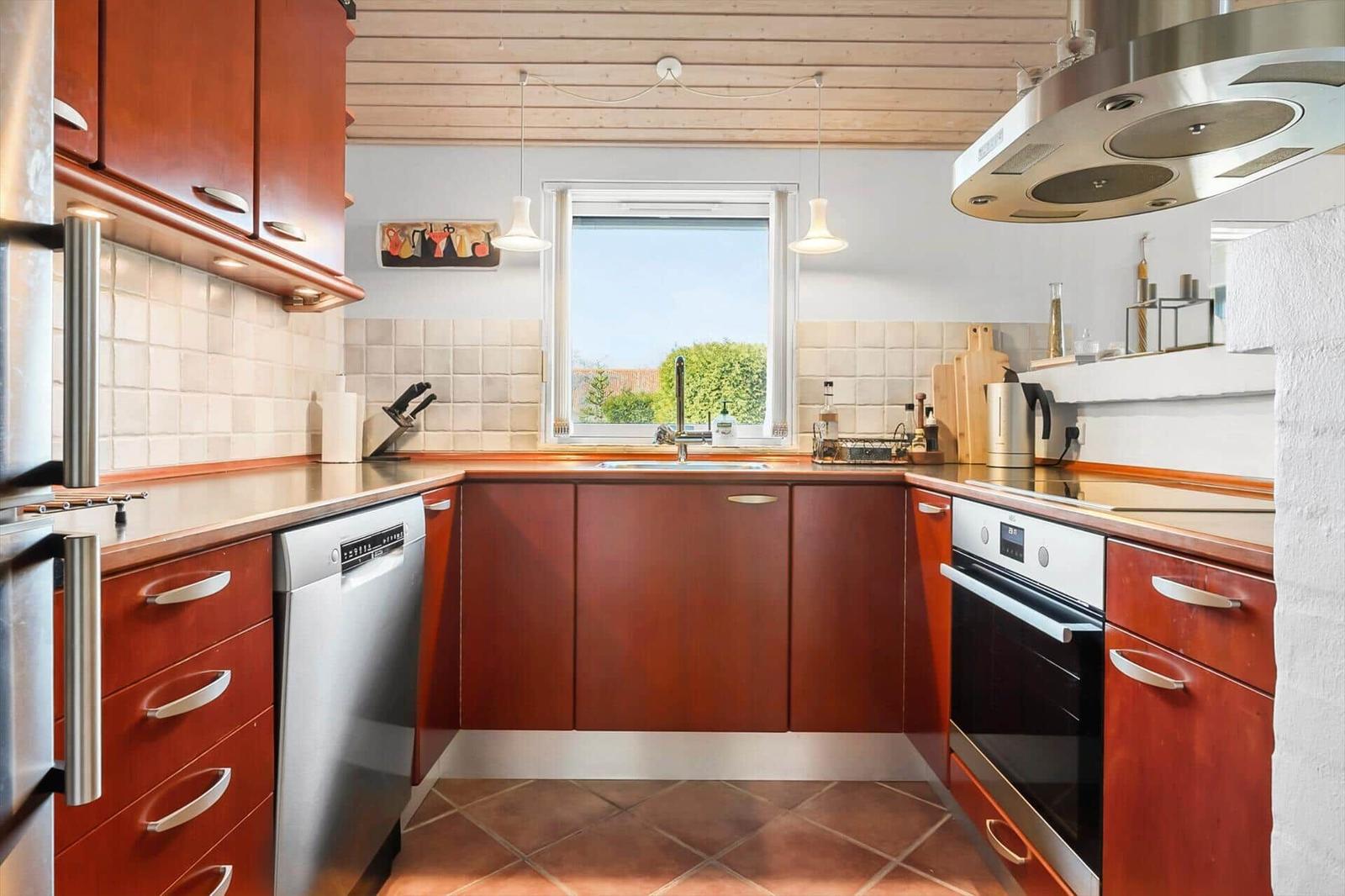 Kitchen with wooden cabinets, sink and window view
