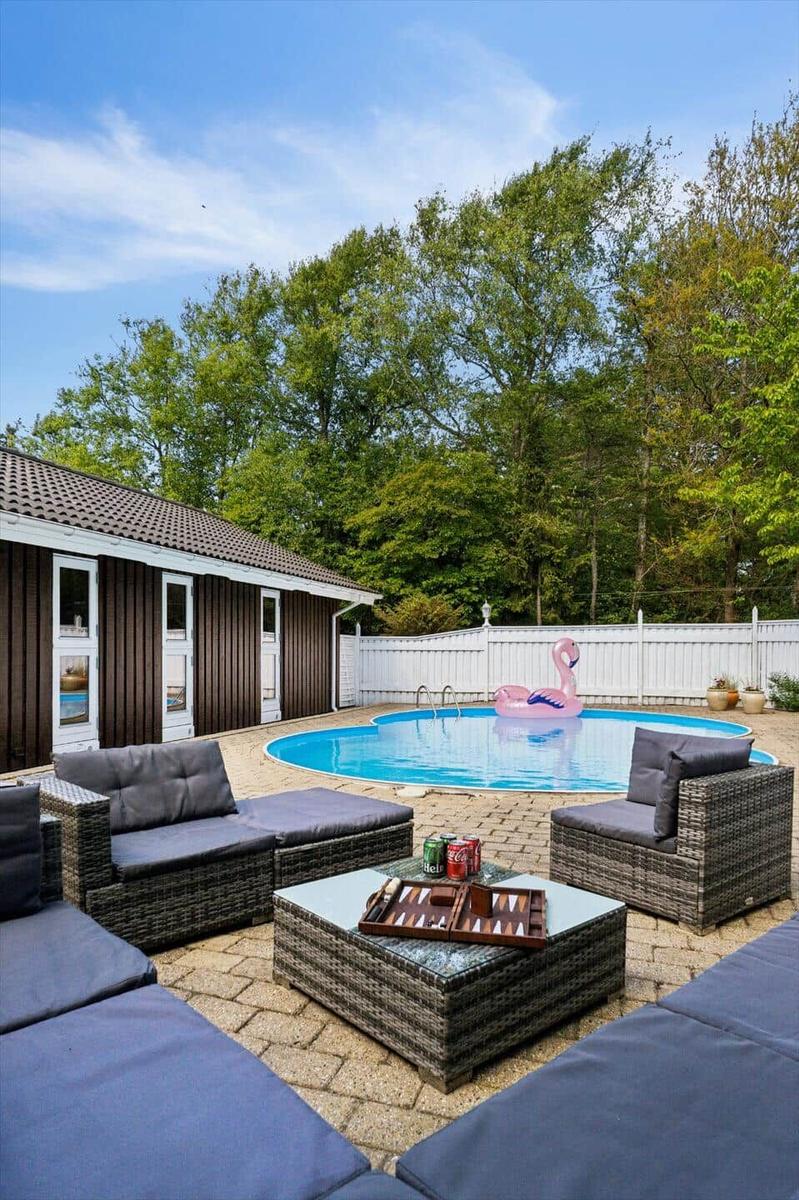 Pool area with loungers, table, and pink flamingo float.