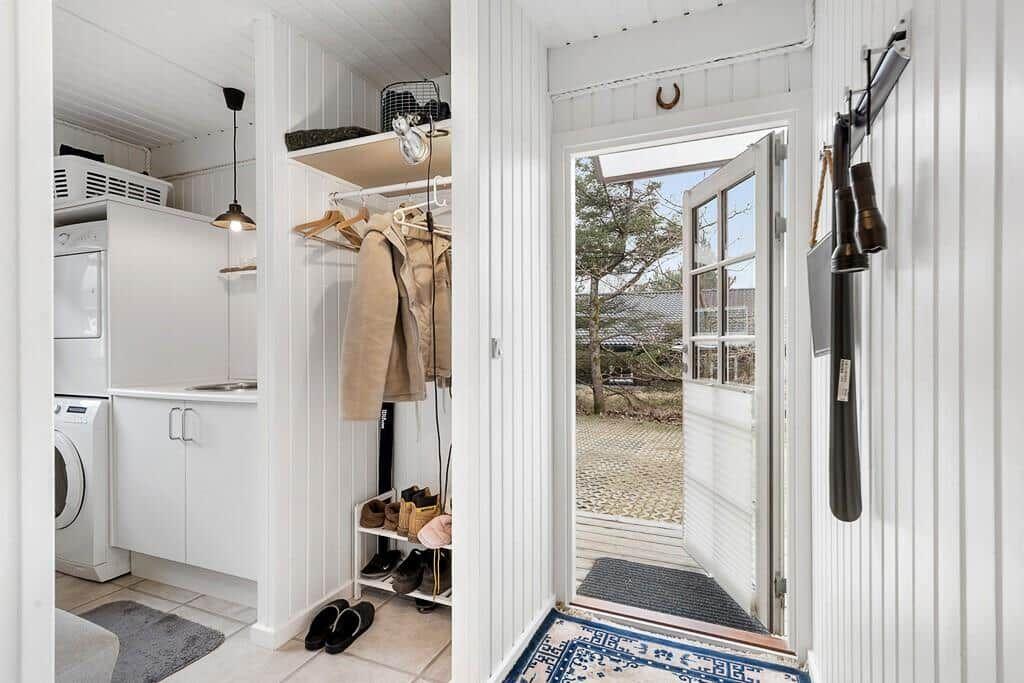Eingangsbereich mit Schuhschrank, Waschmaschine und Blick auf den Hof.
