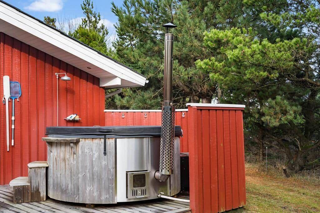 Ein Holzbad mit Metallrohr und roter Umgebung.
