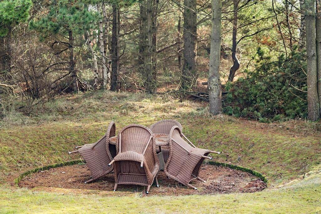 Rattanmöbel auf einer grünen Wiese im Wald