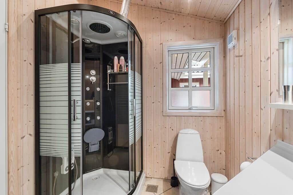 Badezimmer mit Dusche, Toilette und Fenster