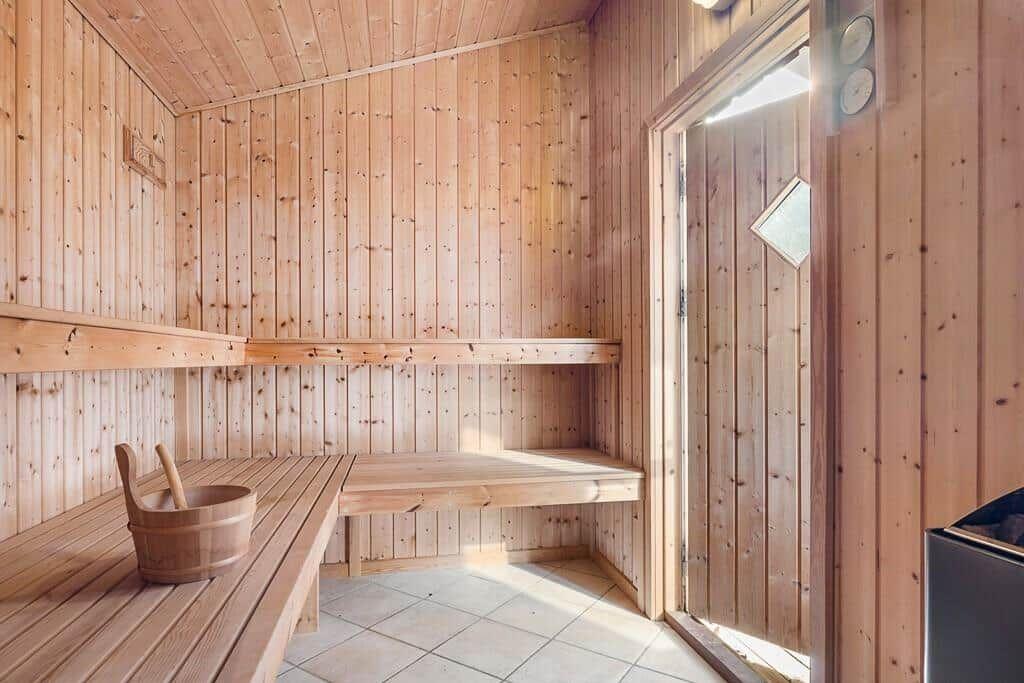 Sauna mit Holzwand, Sitzbänken und Eimer