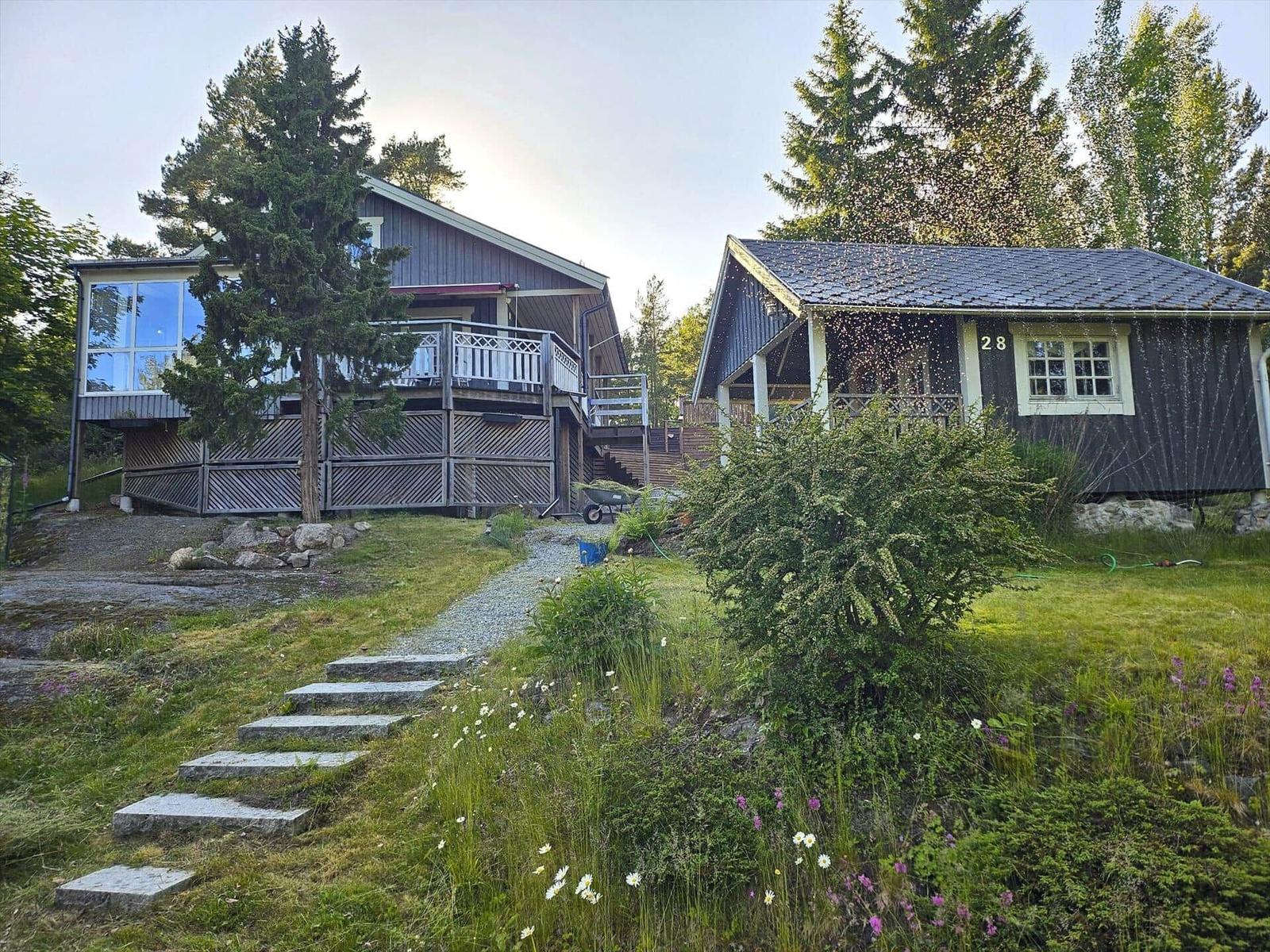 Zwei Häuser mit Terrassen und Gartenweg. Nummer 28 ist sichtbar.