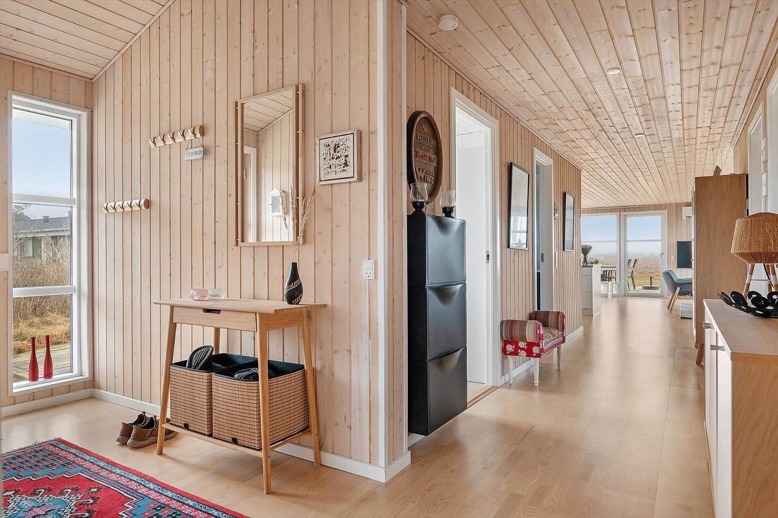 House with wood walls, entry area, shoe storage, and view of terrace.