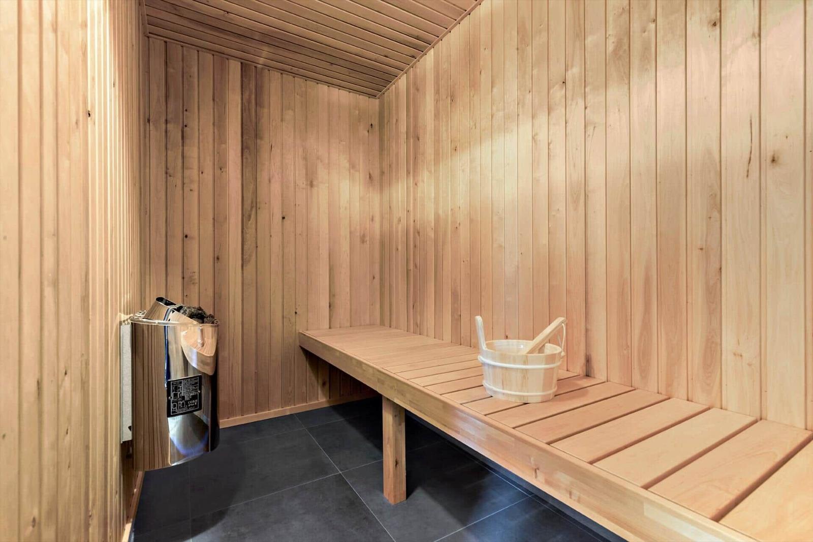 Sauna with wooden walls, bench, and bucket with ladle.