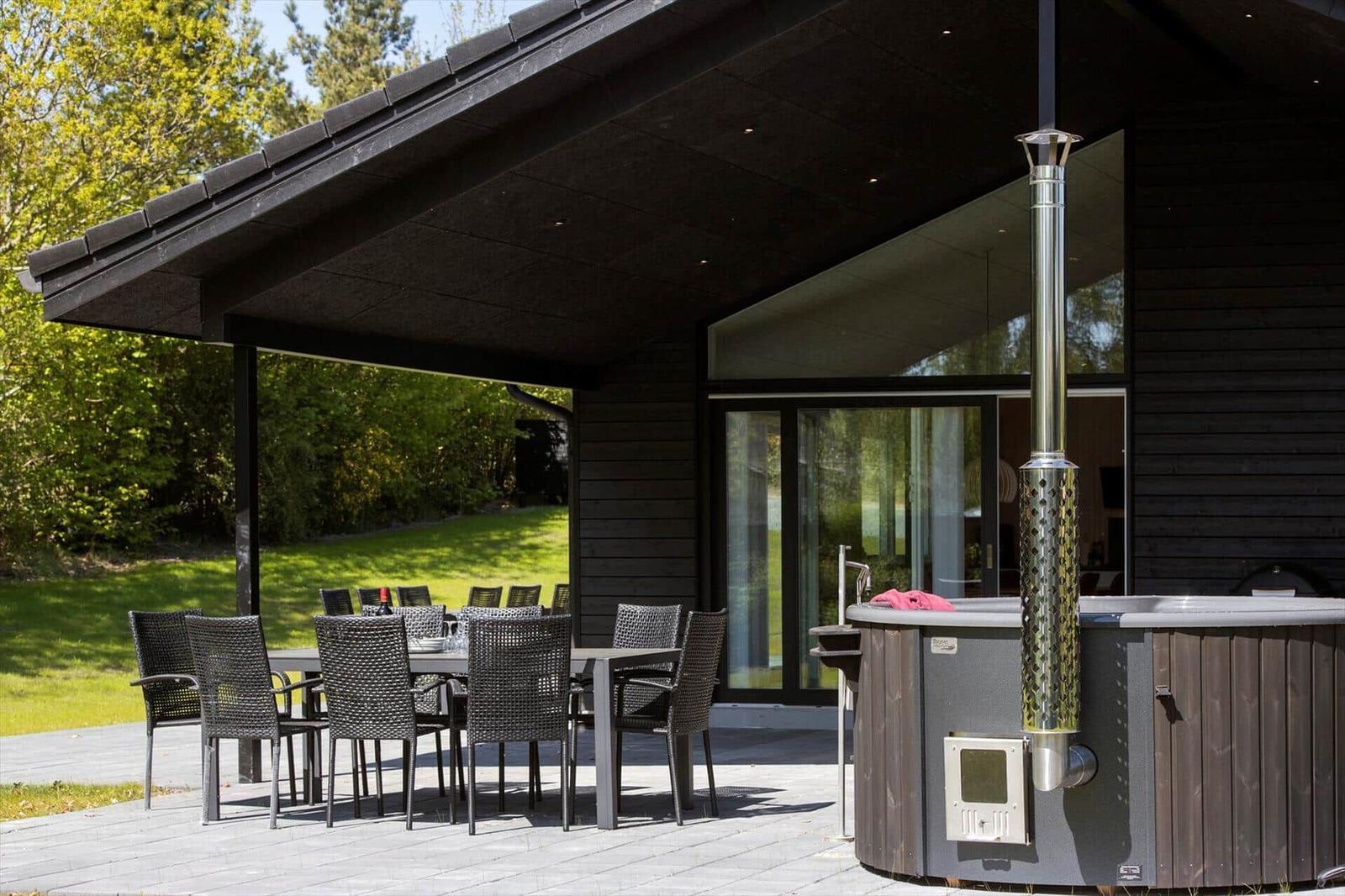 Terrace with table, chairs, and hot tub under roof
