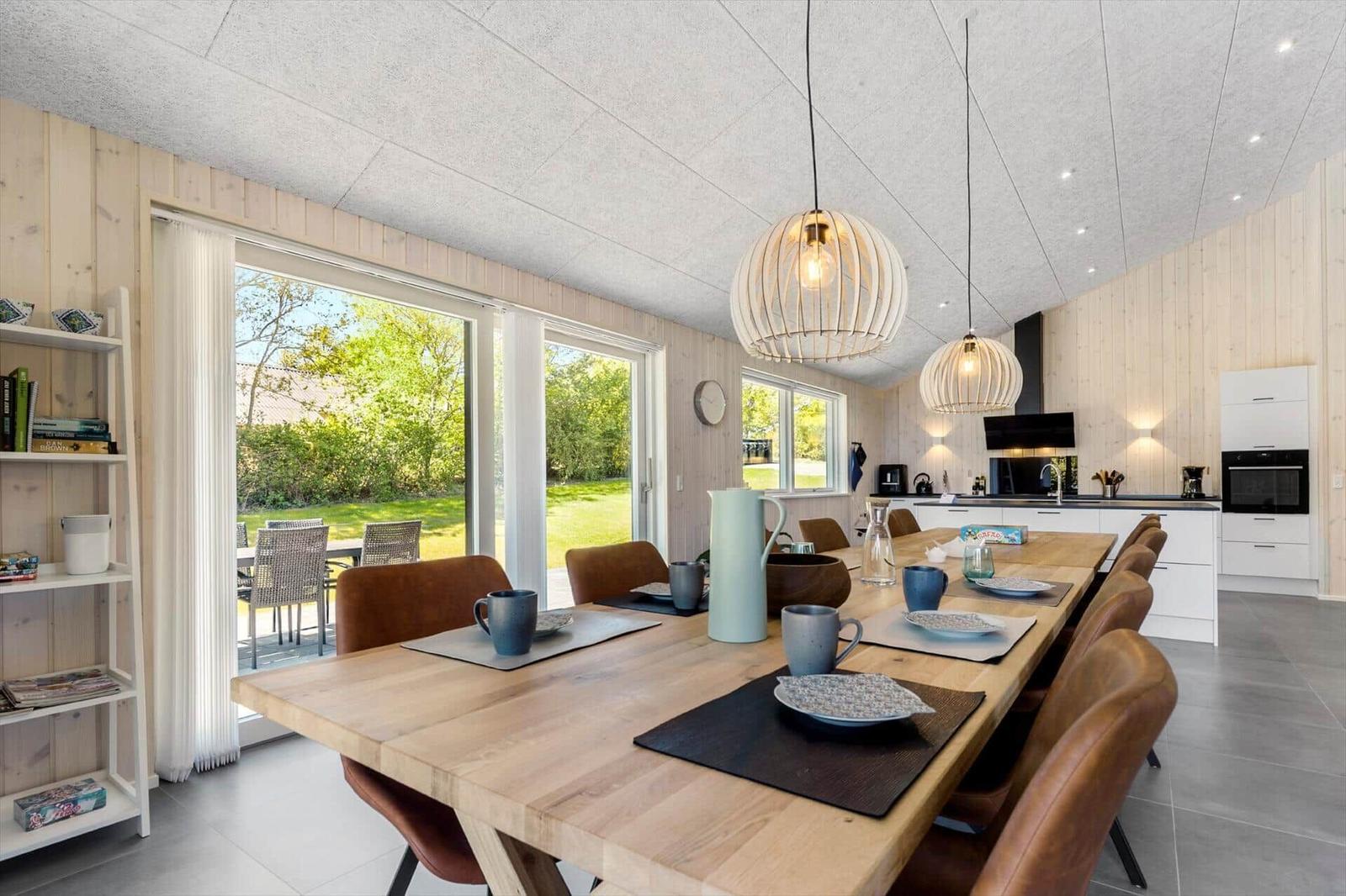 Dining area with wooden table, chairs, and view of the garden