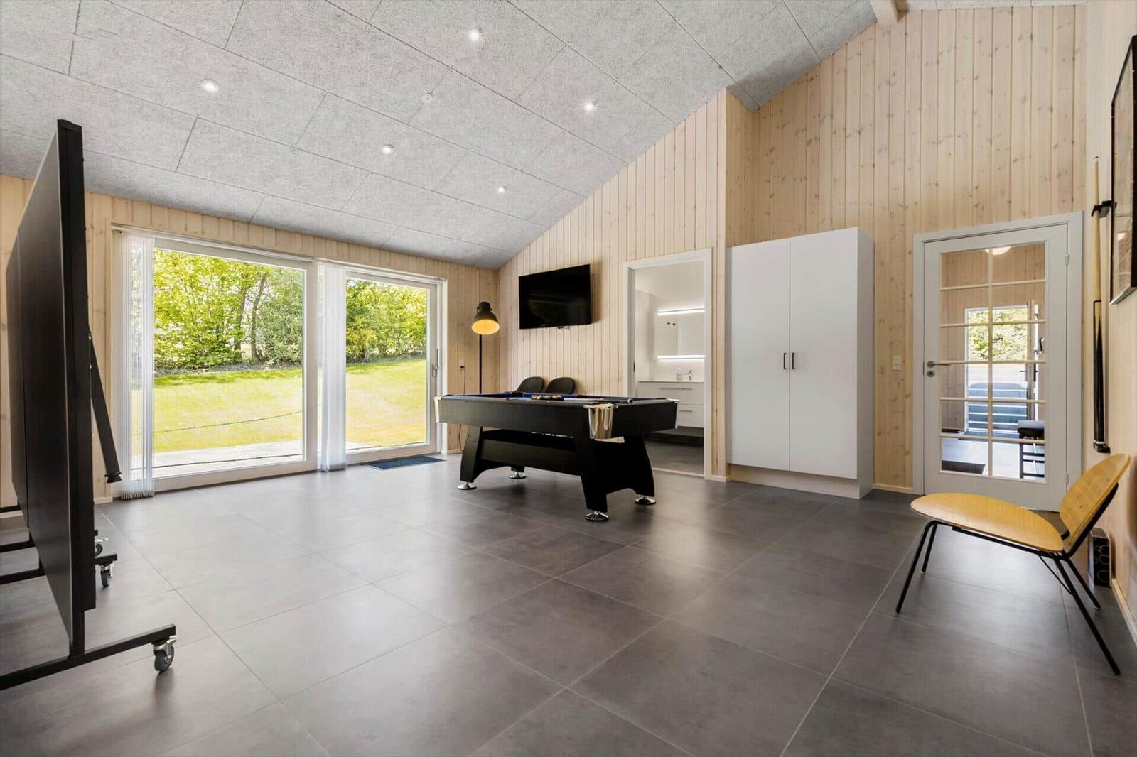 Room with pool table, TV, and view of garden