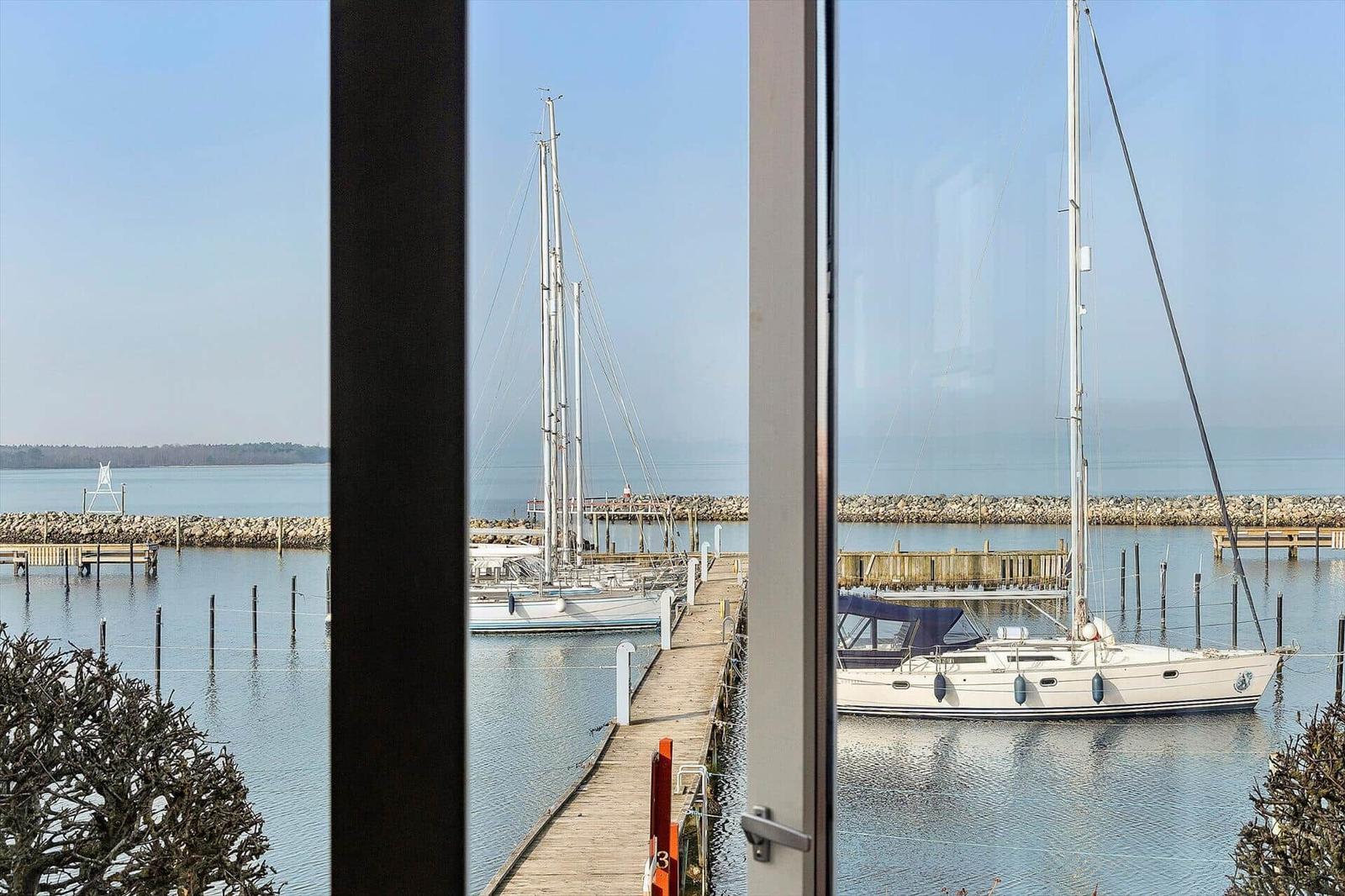 From the window, you can see a harbor with sailboats.