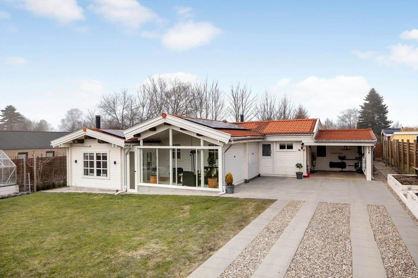 Modernes Haus mit Terrasse, Garage und Garten. Dach mit Solarpanel.