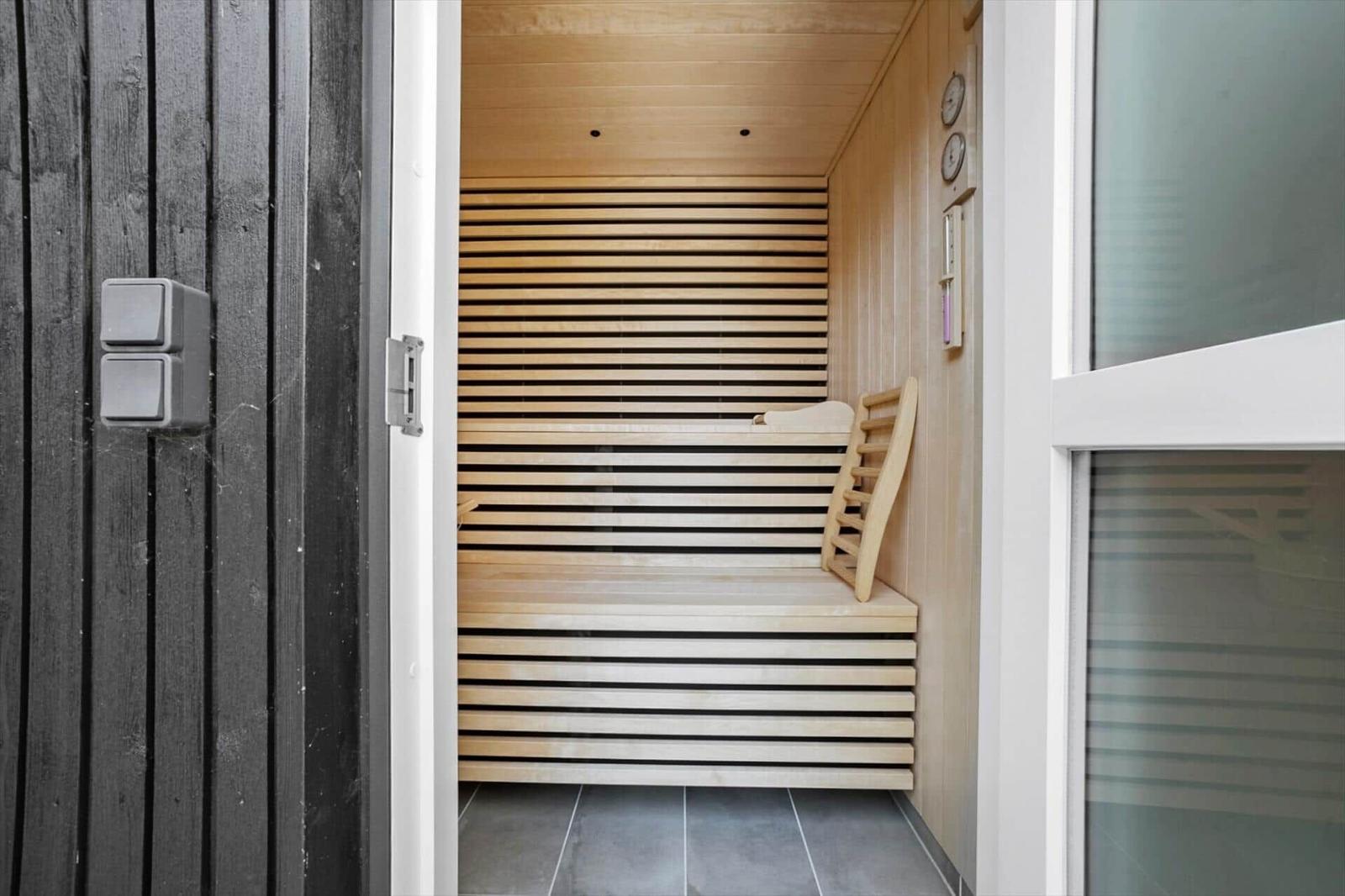 Sauna mit Holzbank und Steuerung an der Wand