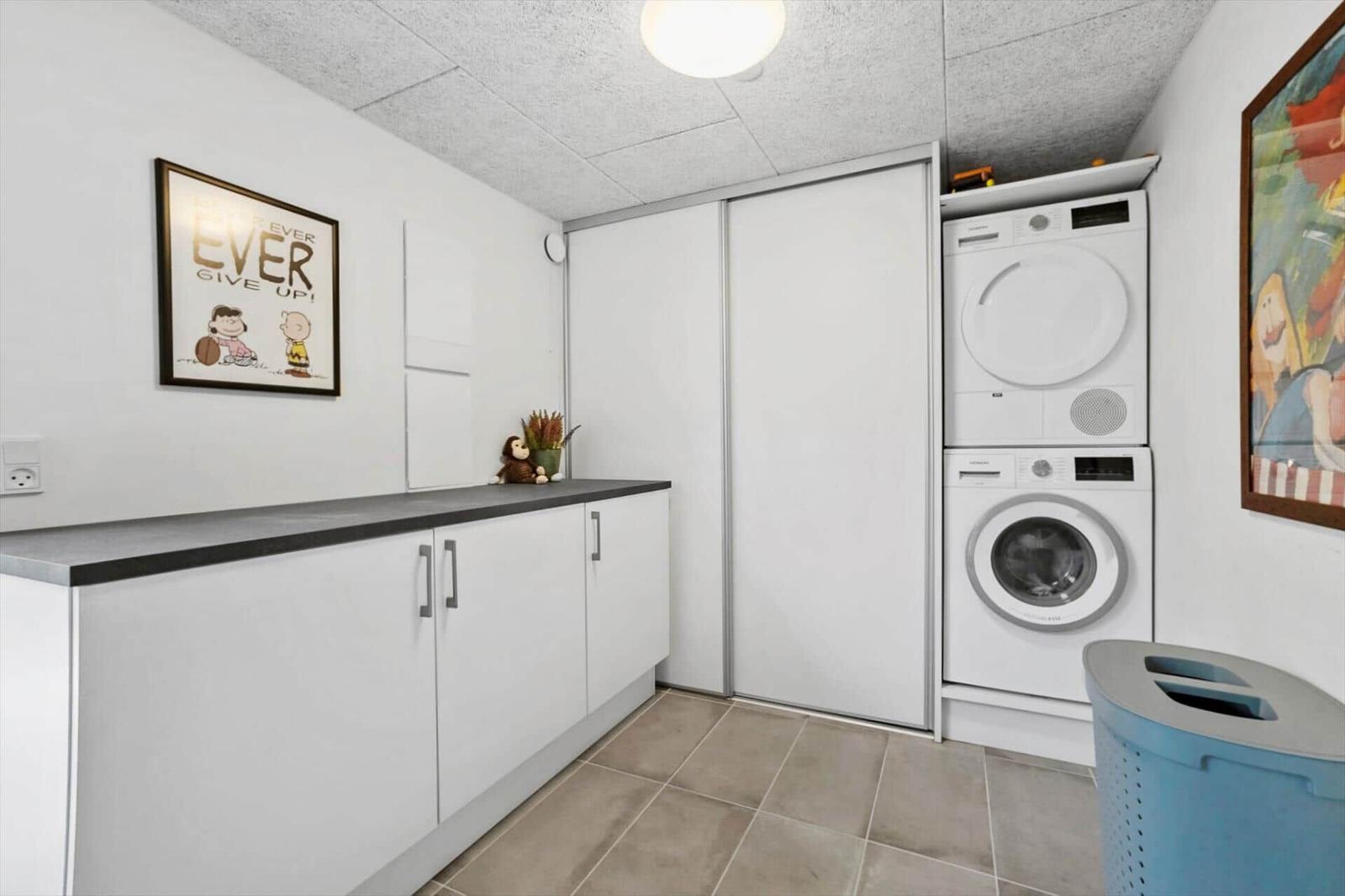 Waschraum mit Waschmaschine, Trockner und Schrank