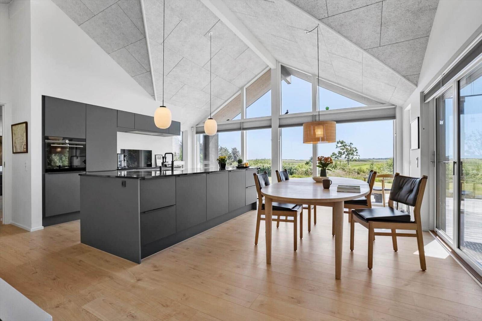 Moderne Küche mit Essbereich und großem Fensterblick.