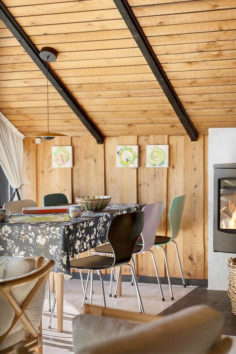 Essbereich mit Tisch, Stühlen und Kamin im Holzhaus.