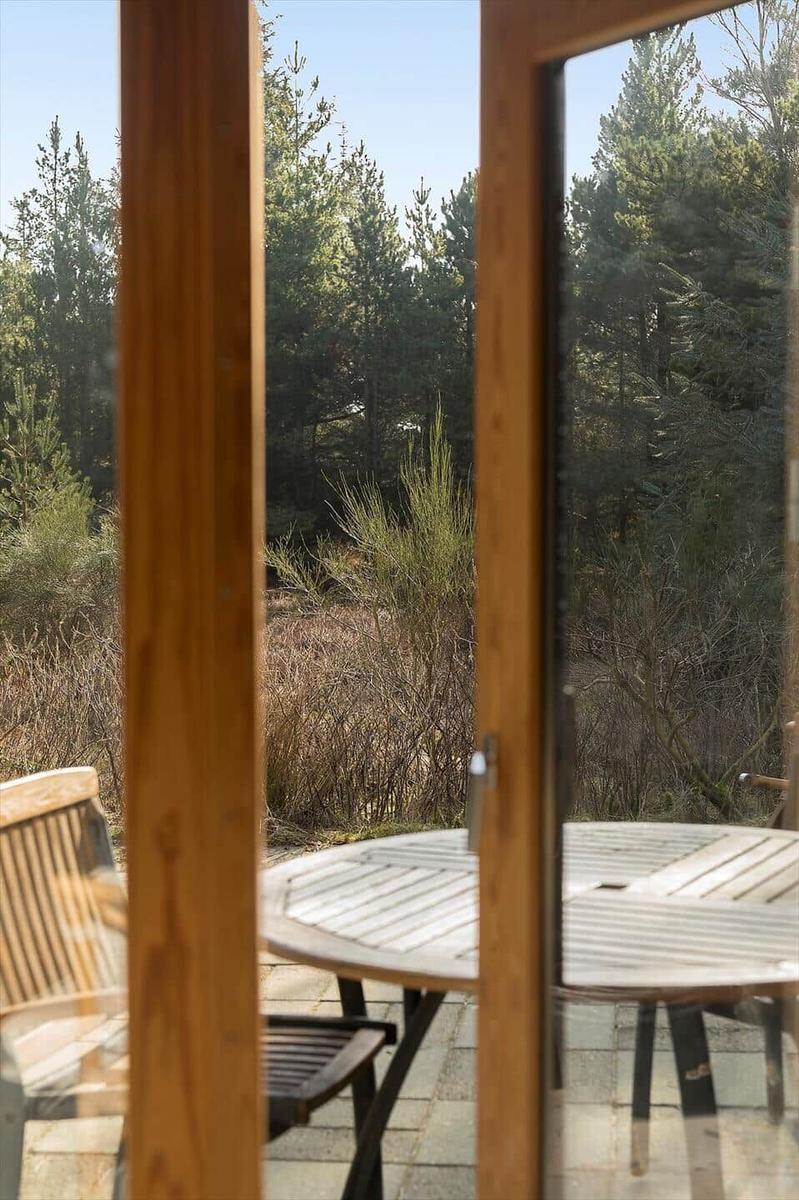 Terrasse mit Tisch und Stühlen, Blick in den Wald.