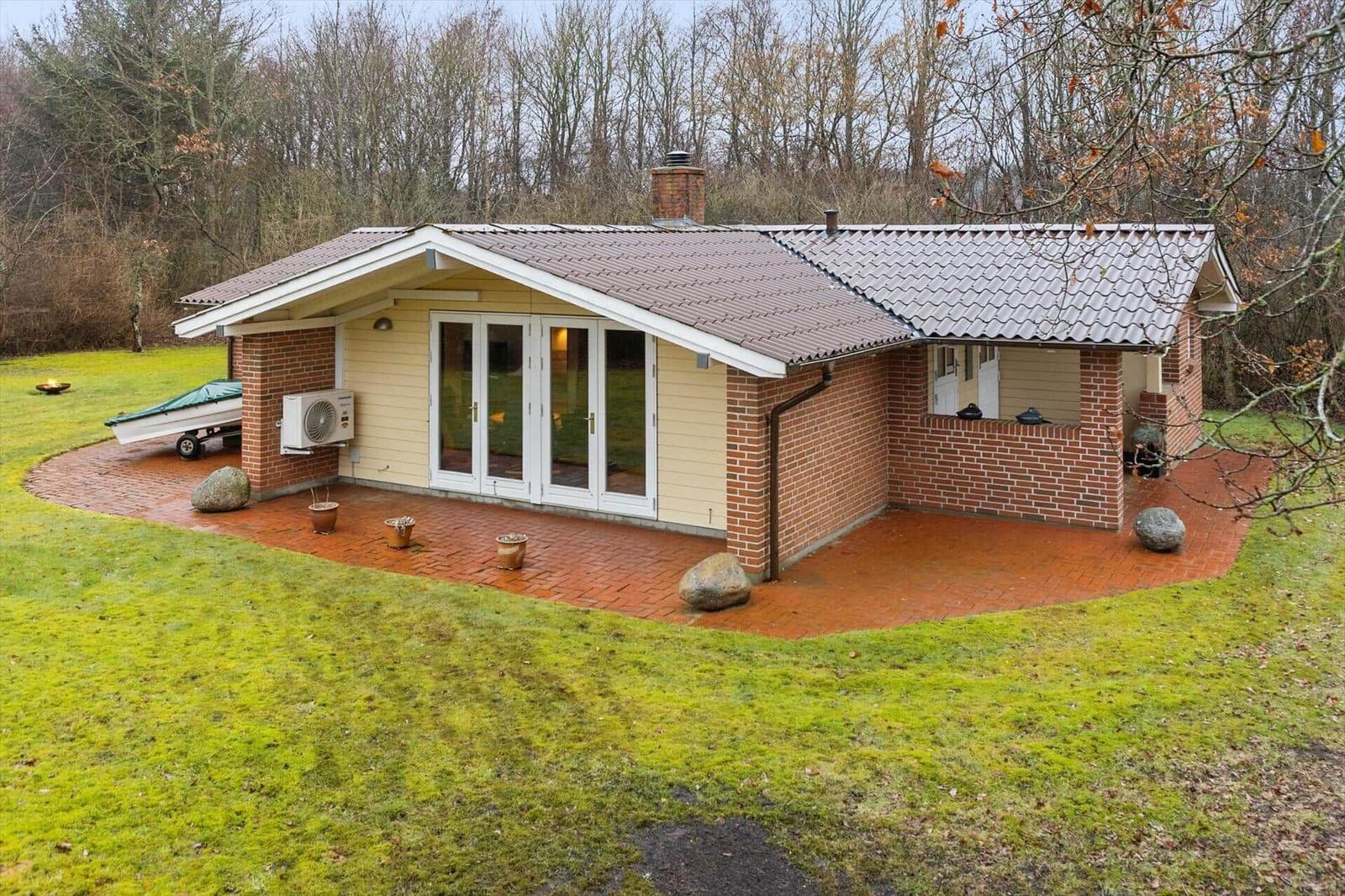 Haus mit Terrasse, Garten und Boot auf Anhänger