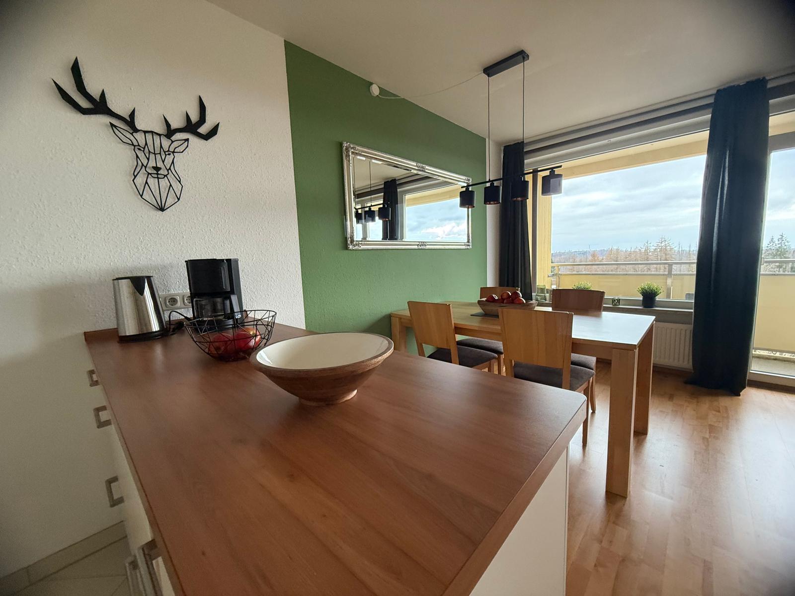 Küche mit Essbereich und Balkonansicht. Wanddekoration und Holzmöbel.