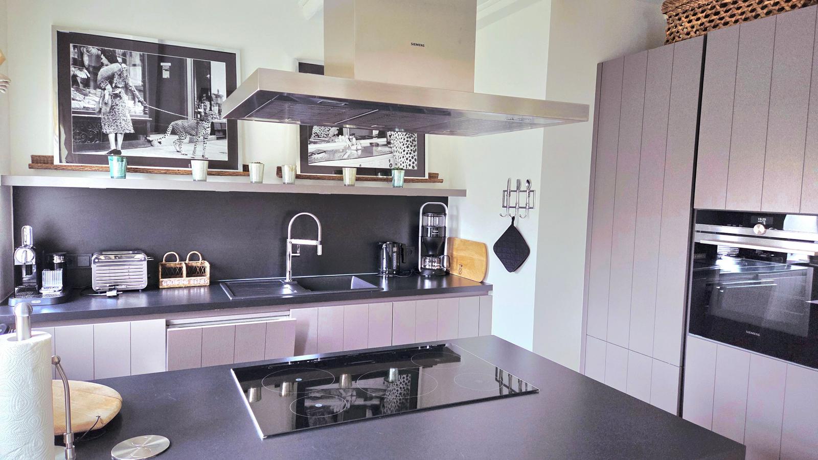 Moderne Küche mit Edelstahl-Abluft und integriertem Herd.