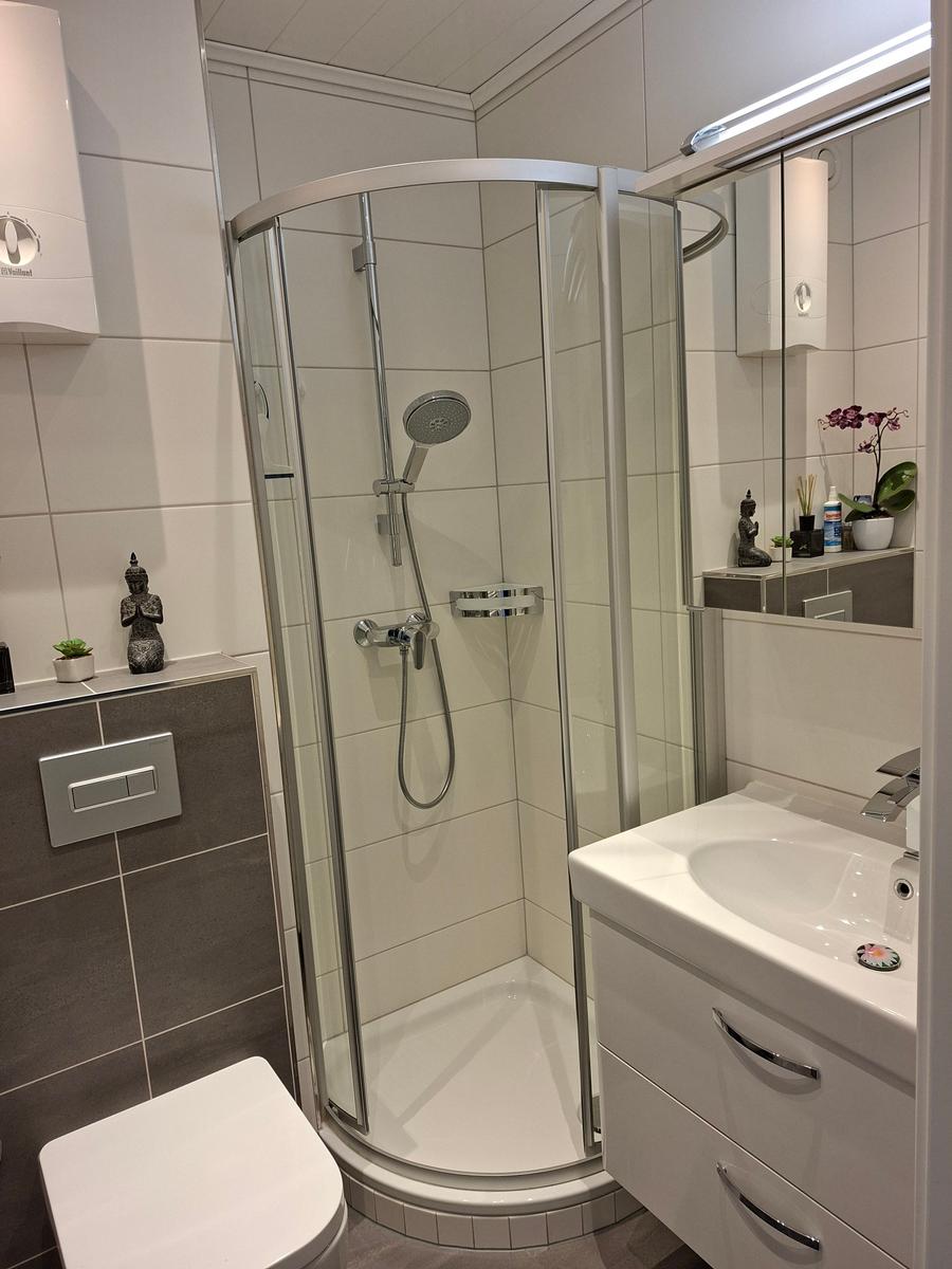 Badezimmer mit Dusche, Waschbecken und Toilette