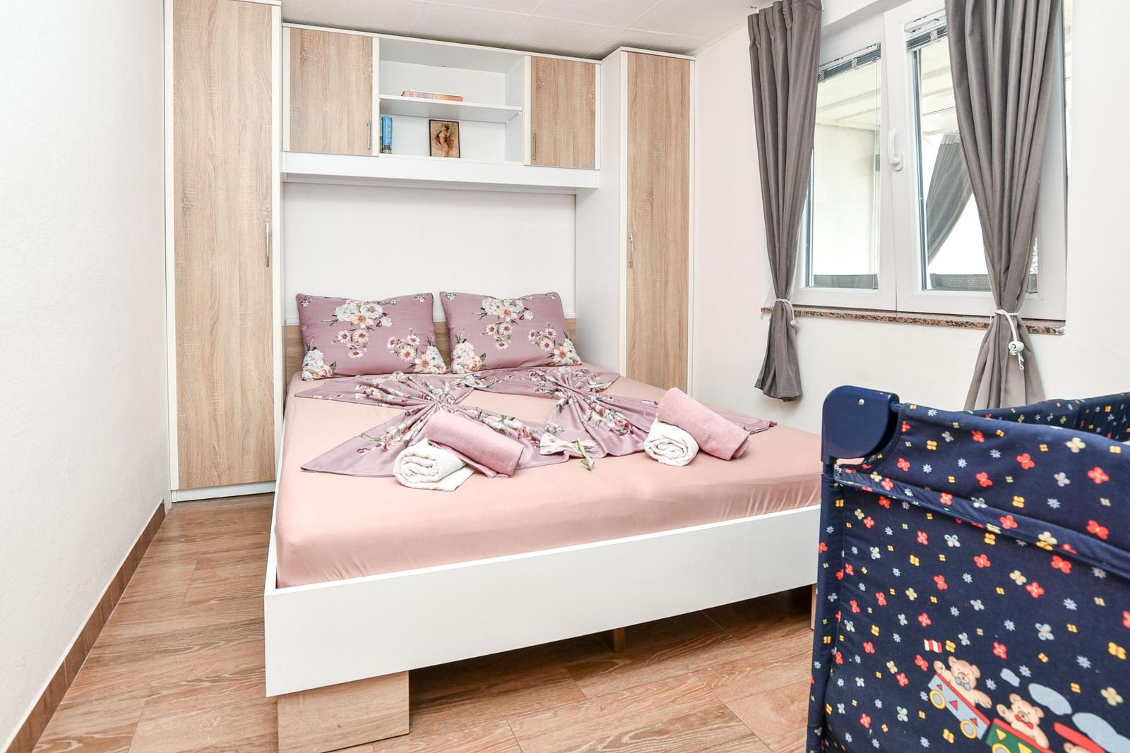 Schlafzimmer mit Bett, Schrank und Fenster