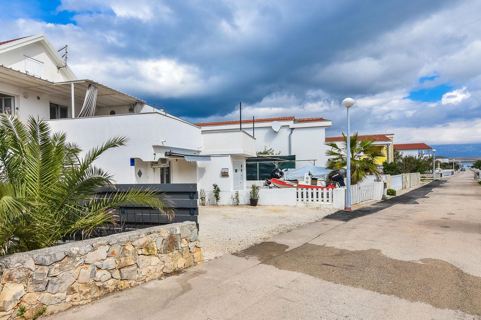 Wohnhaus mit Terrasse und Motorboot an der Küste.