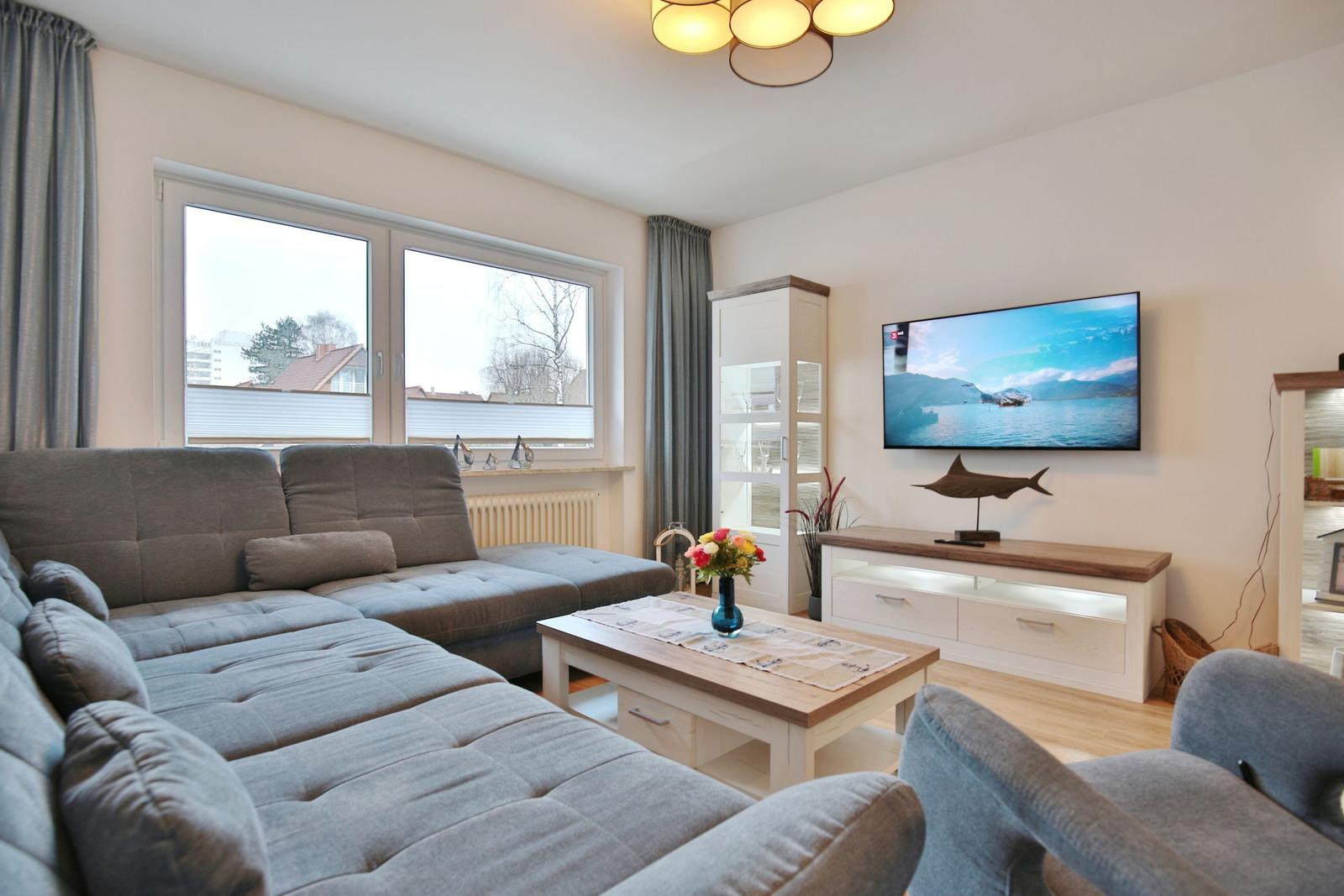 Wohnzimmer mit Sofa, Fernseher und Tisch