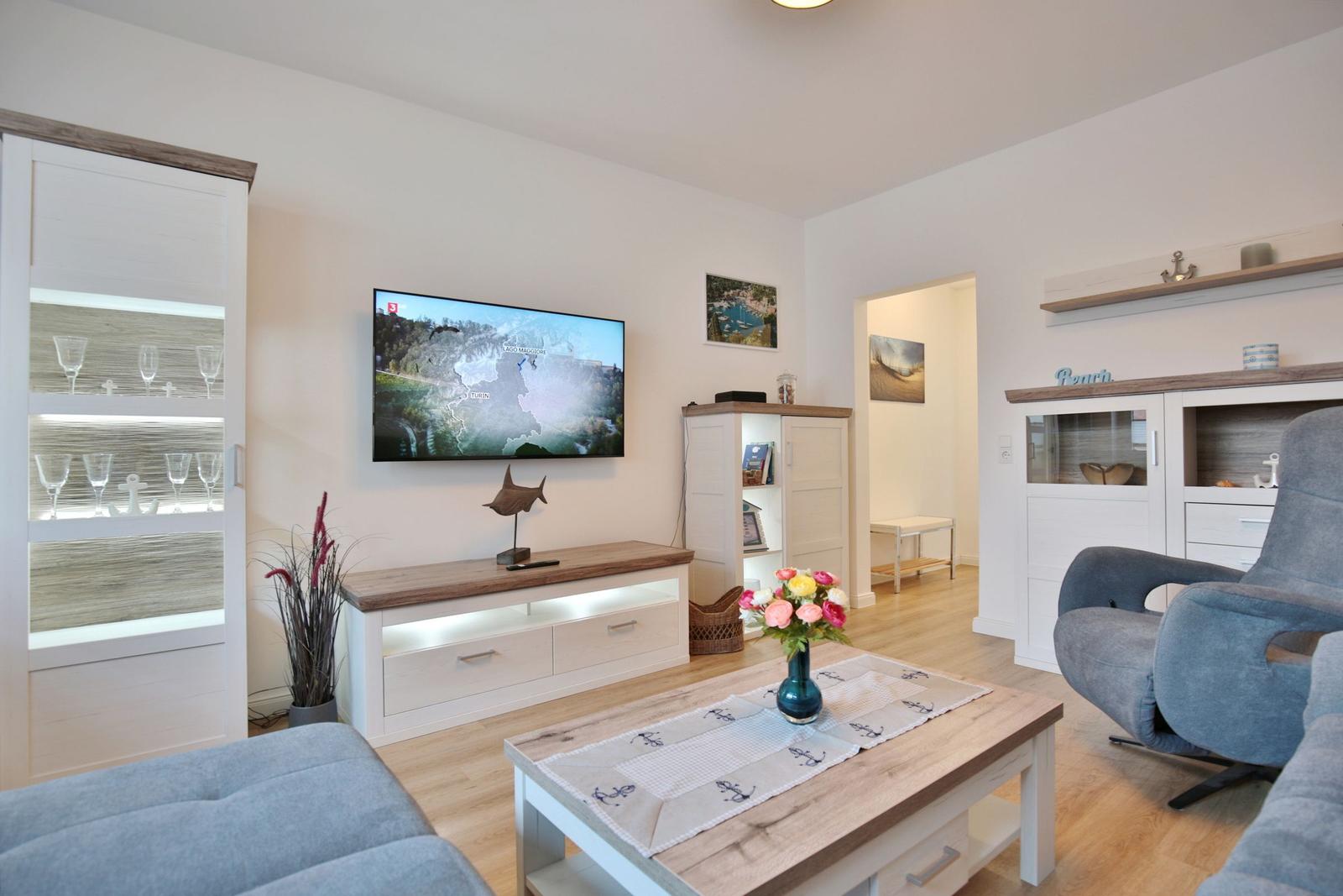 Wohnzimmer mit Fernseher, Couch und Tisch